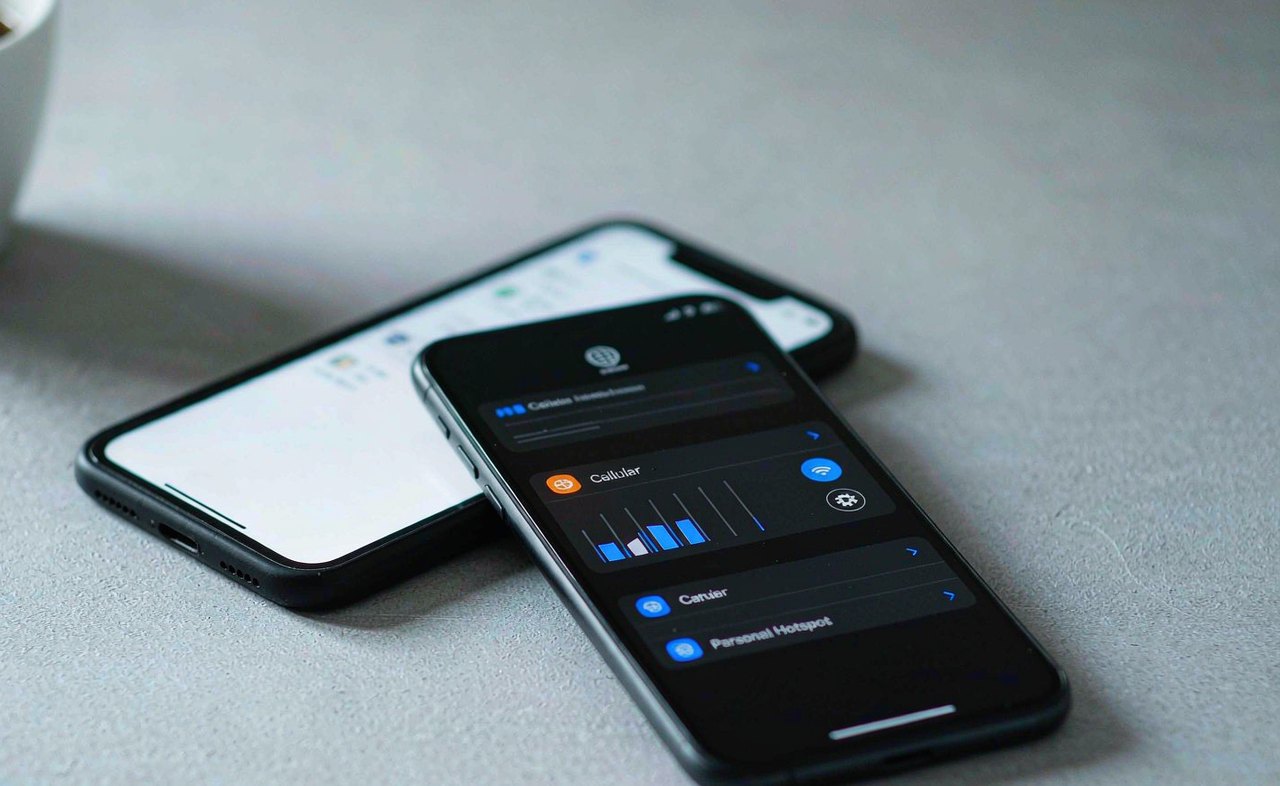 Two smartphones side by side on a table, one showing a cellular settings screen