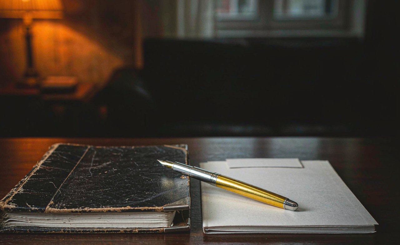 Two insurance policy folders side by side on a wooden desk, one thick and one thin
